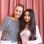Symbolbild: Mentorin und Mentee stehen lächelnd nebeneinander